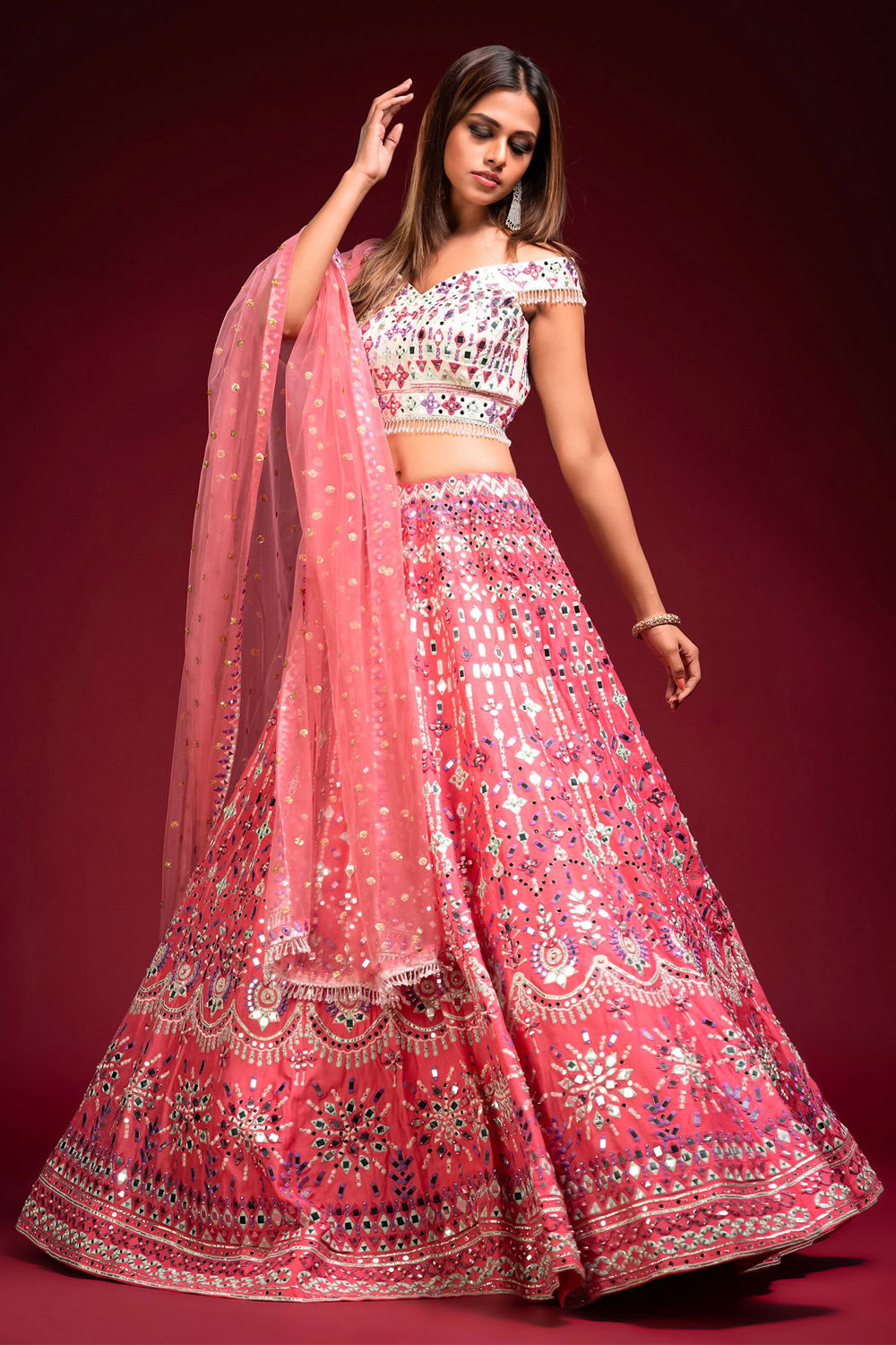 BRICK BLUSH PINK LEHENGA AND A CONTRAST IVORY OFF THE SHOULDER BLOUSE WITH  MULTI COLOURED EMBROIDERY AND “ABLA” PAIRED WITH A MATCHING PINK DUPATTA  AND TASSELS - Seasons India